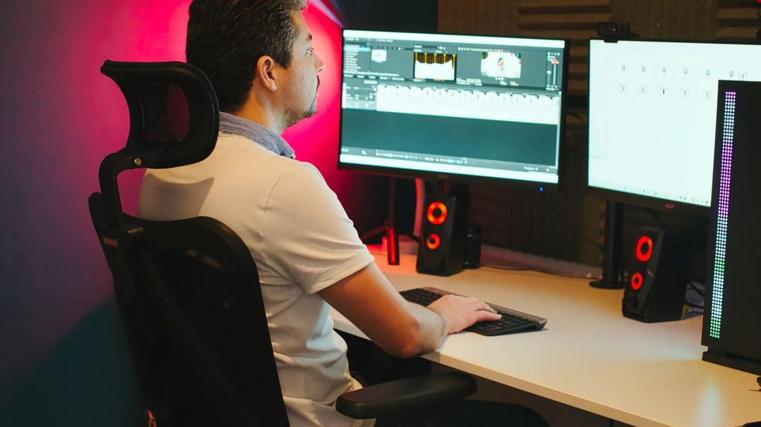 Man sitting on an ergonomic chair with text overlay explaining reasons why you need to have an ergonomic chair