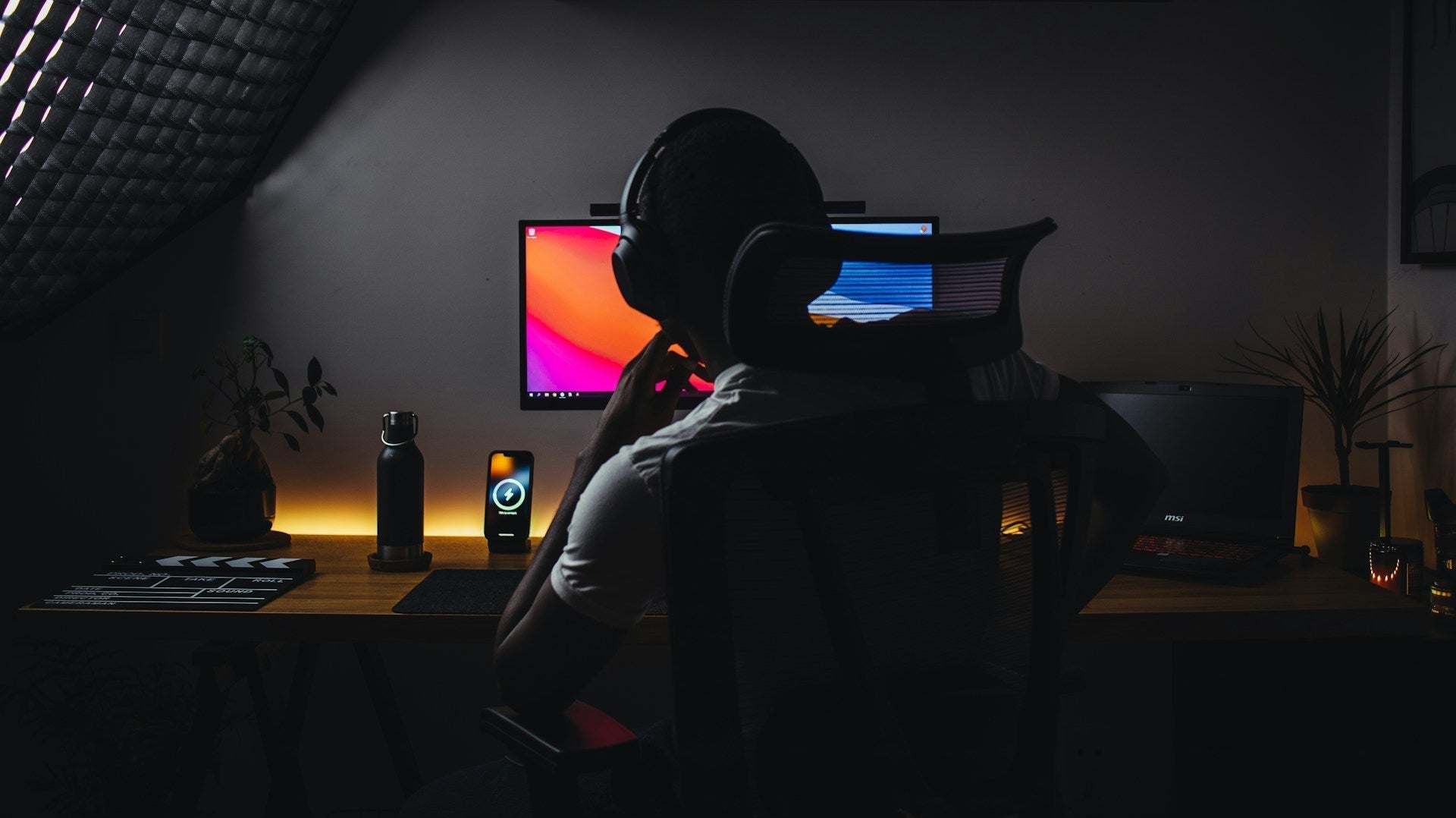 a person wearing headphones sitting in front of a computer using ergonomic chair in Australia