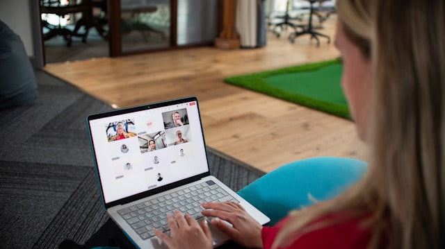 Woman on a laptop in a video conference call, illustrating the advantages of working from home for employers through remote collaboration and improved efficiency.