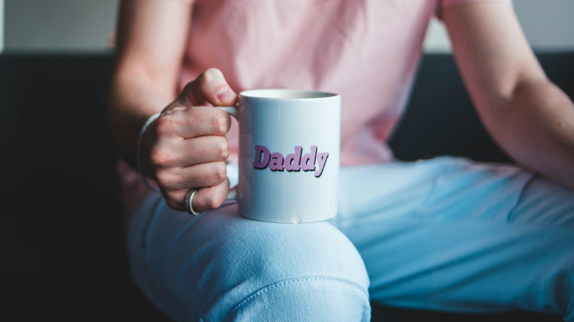 A man holding a white mug with the word Daddy in pink letters, representing thoughtful and simple father’s day gift ideas for every dad. Image by Erik Mclean via Unsplash