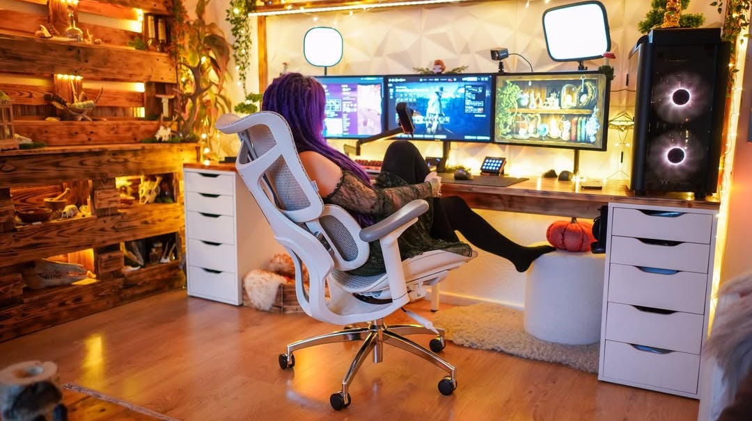 Gamer in a setup with three monitors and ergonomic gaming chair, showing the importance of gaming chair ergonomics for comfort.