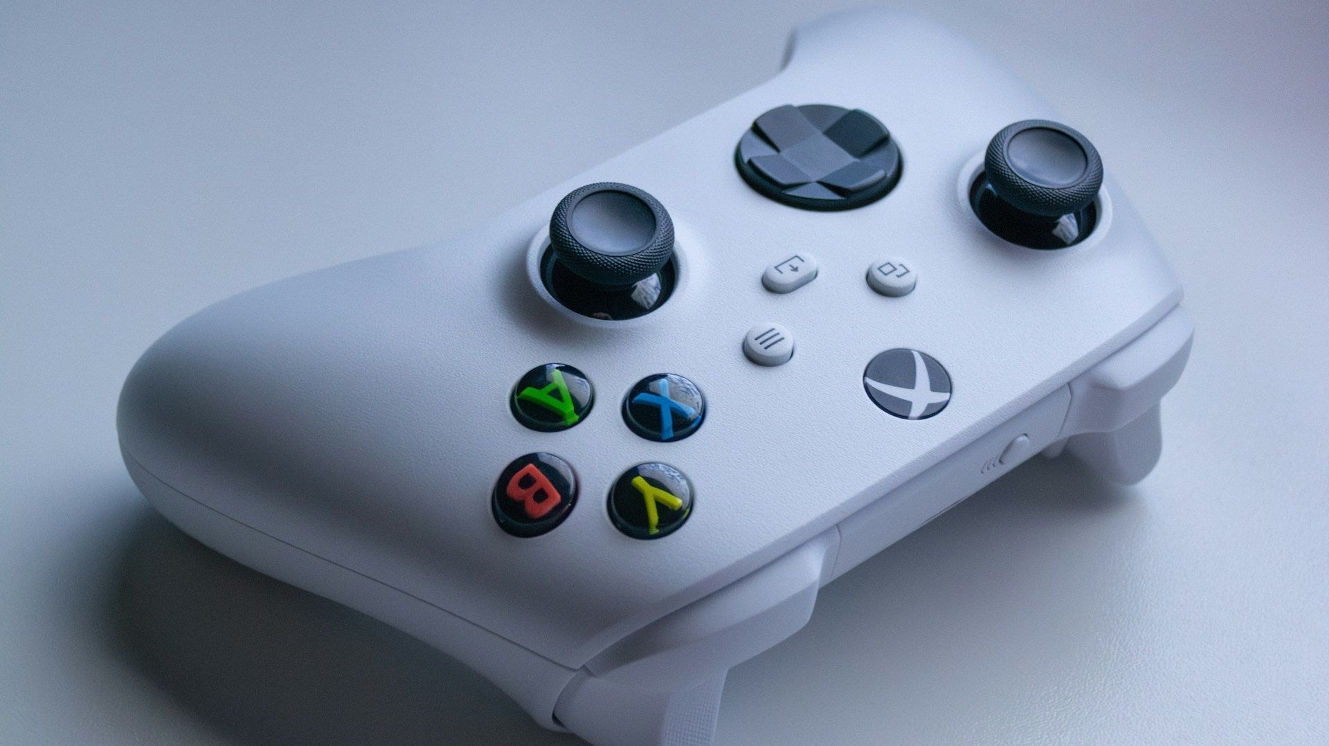 White wireless gaming controller on a smooth desk surface, perfect for a minimalist gaming setup white aesthetic.