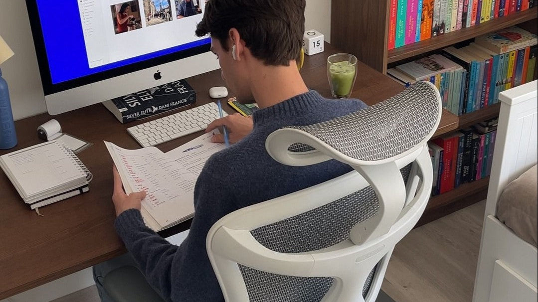 Man working while seated on an ergonomic chair, promoting focus and productivity at work.