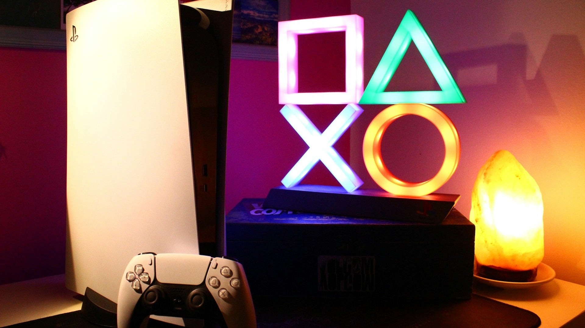 A row of gaming consoles placed on a table in dimly lit room, insipiring the question which gaming console should i buy. IMage by Roberto Vincenzo Minasi via www.unsplash.com