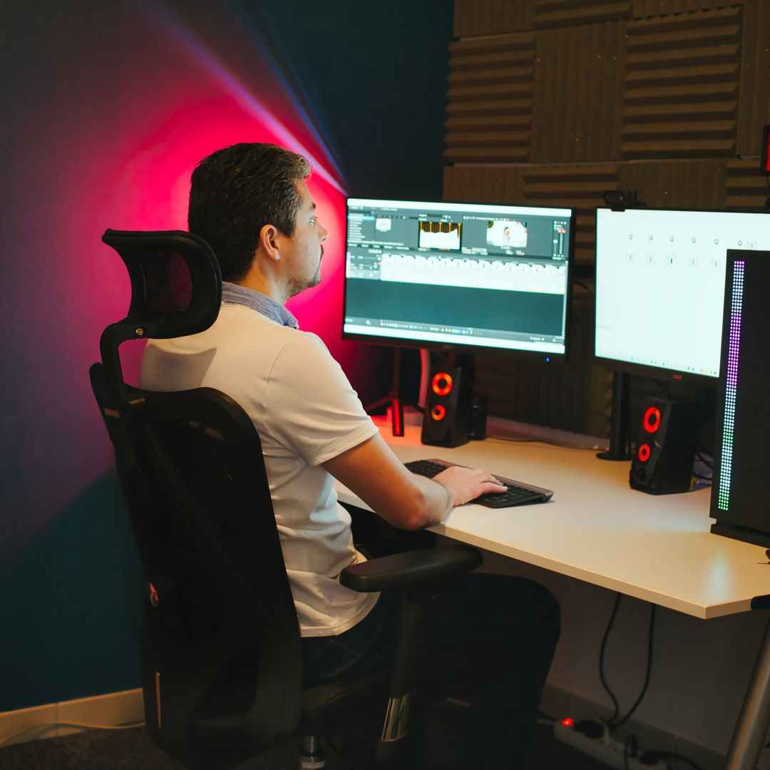 Man sitting on an ergonomic chair with text overlay explaining reasons why you need to have an ergonomic chair