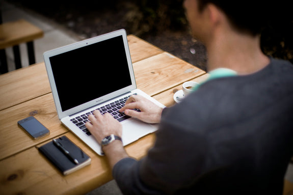 Person working on a laptop outdoors while maintaining good posture, illustrating the topic Are Posture Correctors Good for You Long Term.