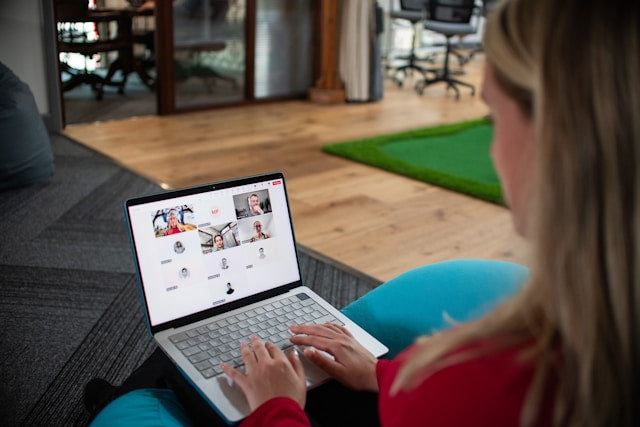 Woman on a laptop in a video conference call, illustrating the advantages of working from home for employers through remote collaboration and improved efficiency.