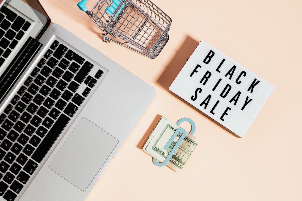 Black Friday sale banner top view featuring a laptop, shopping cart, and an ergonomic chair, highlighting online deals and office furniture discounts.