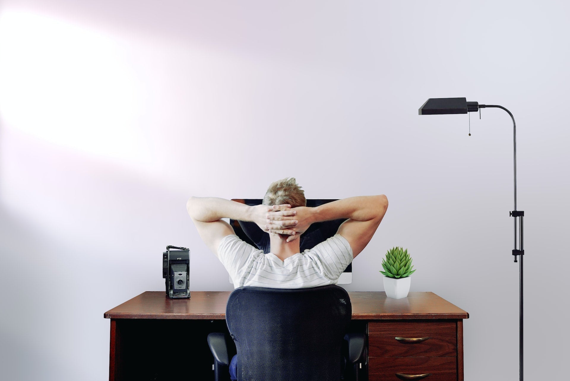Back view of a man sitting on the best ergonomic chair in Australia, showcasing proper posture, lumbar support, and comfortable ergonomic design.