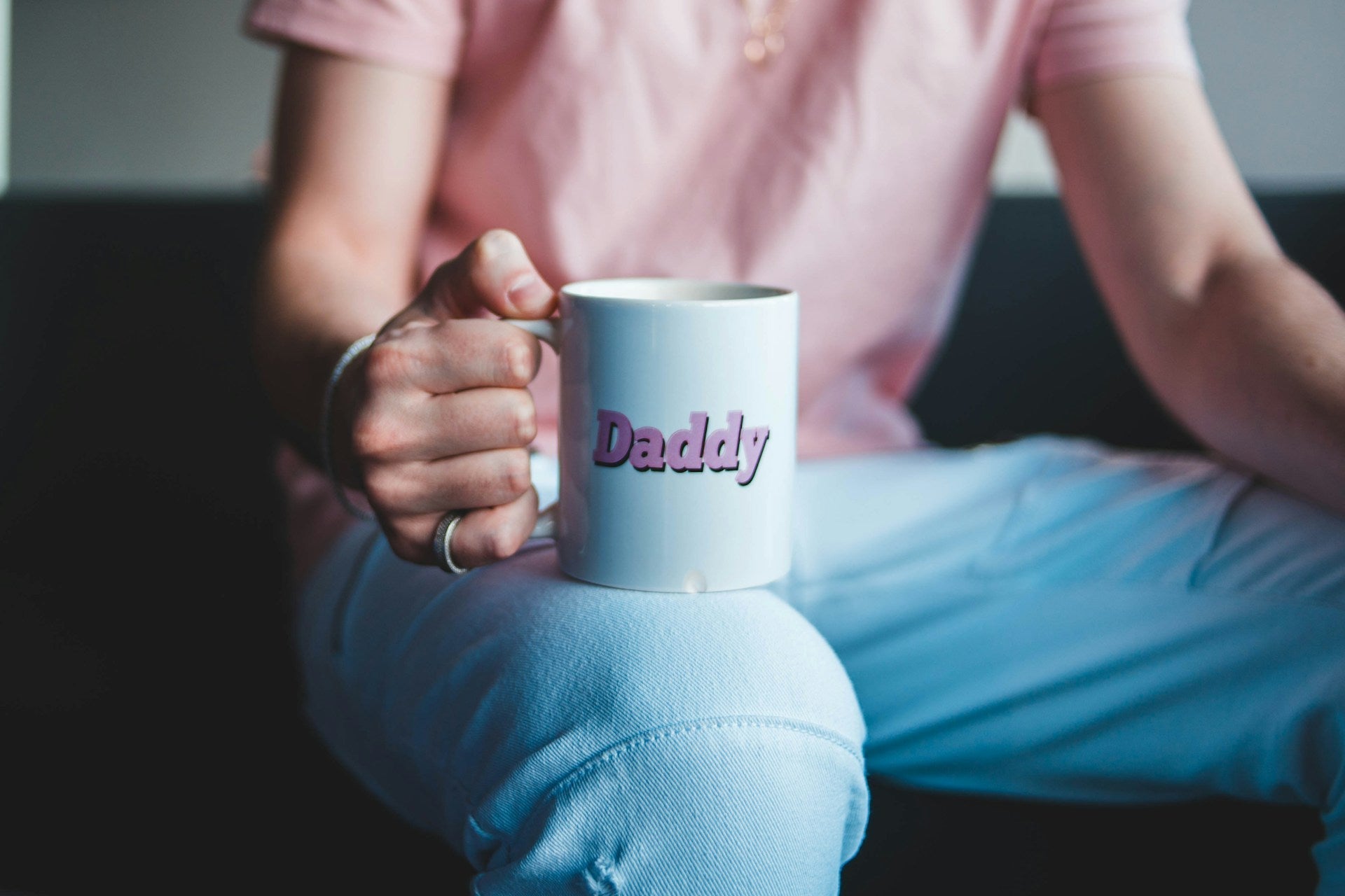 A man holding a white mug with the word Daddy in pink letters, representing thoughtful and simple father’s day gift ideas for every dad. Image by Erik Mclean via Unsplash