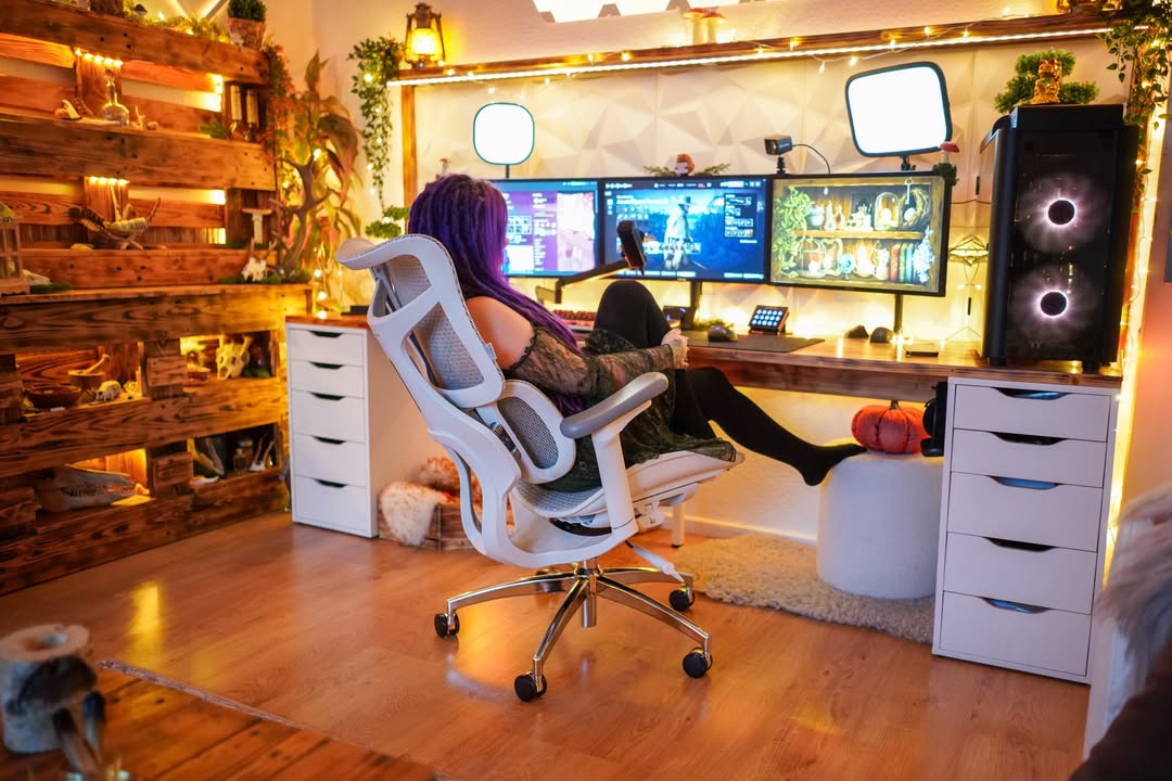 Gamer in a setup with three monitors and ergonomic gaming chair, showing the importance of gaming chair ergonomics for comfort.
