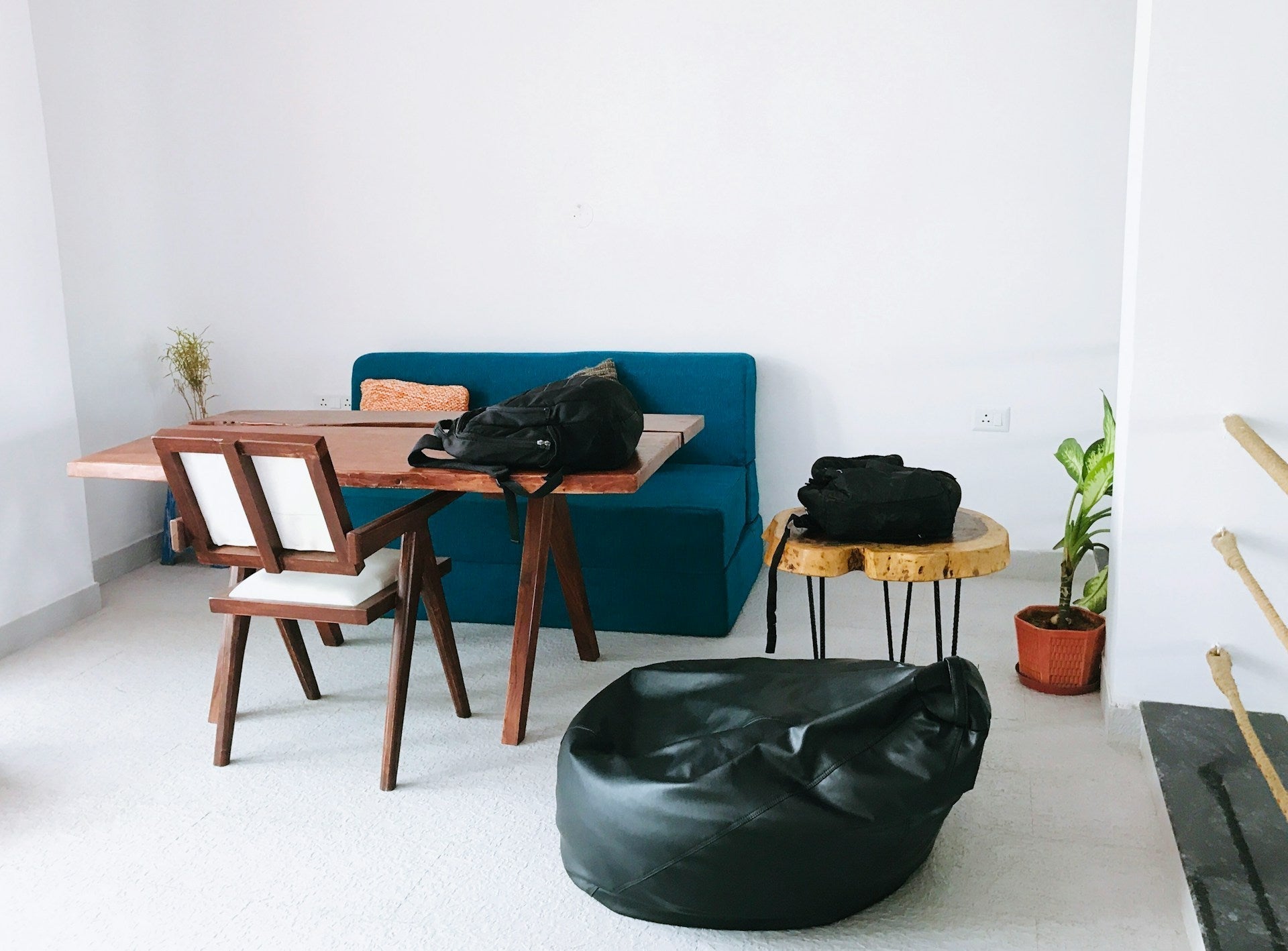 Minimalist room with table, chairs, and a black bean bag, showing casual seating alternatives to a gaming chair or bean bag