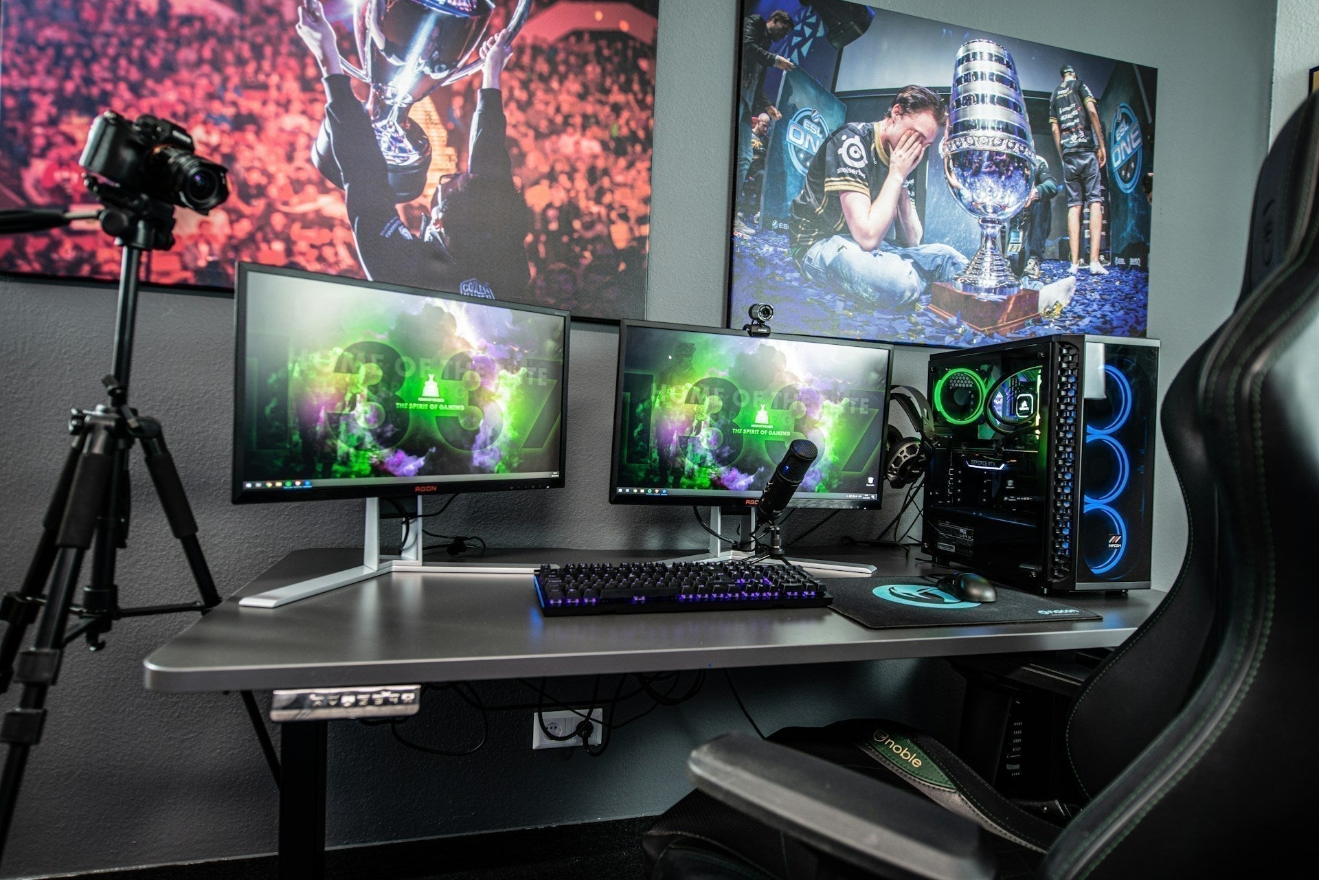 Professional gaming setup dual monitor with RGB PC, gaming chair, and streaming gear in a modern room.