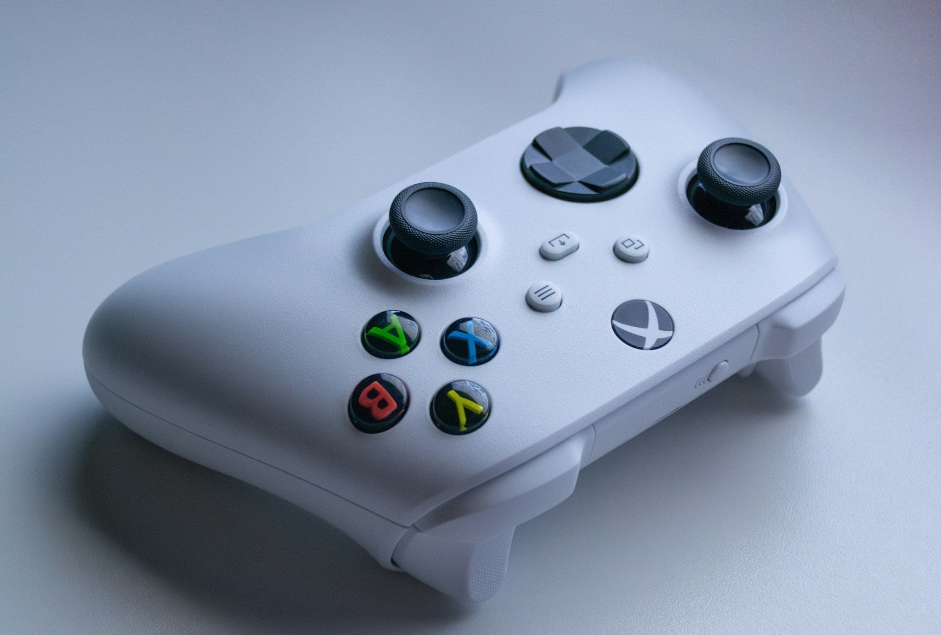 White wireless gaming controller on a smooth desk surface, perfect for a minimalist gaming setup white aesthetic.