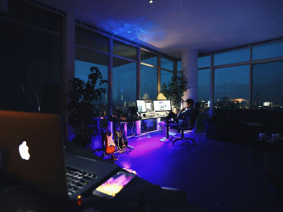 Home office lighting with multiple screens, desk lamp, and night city view. Image by Roberto Nickson via www.unsplash.com