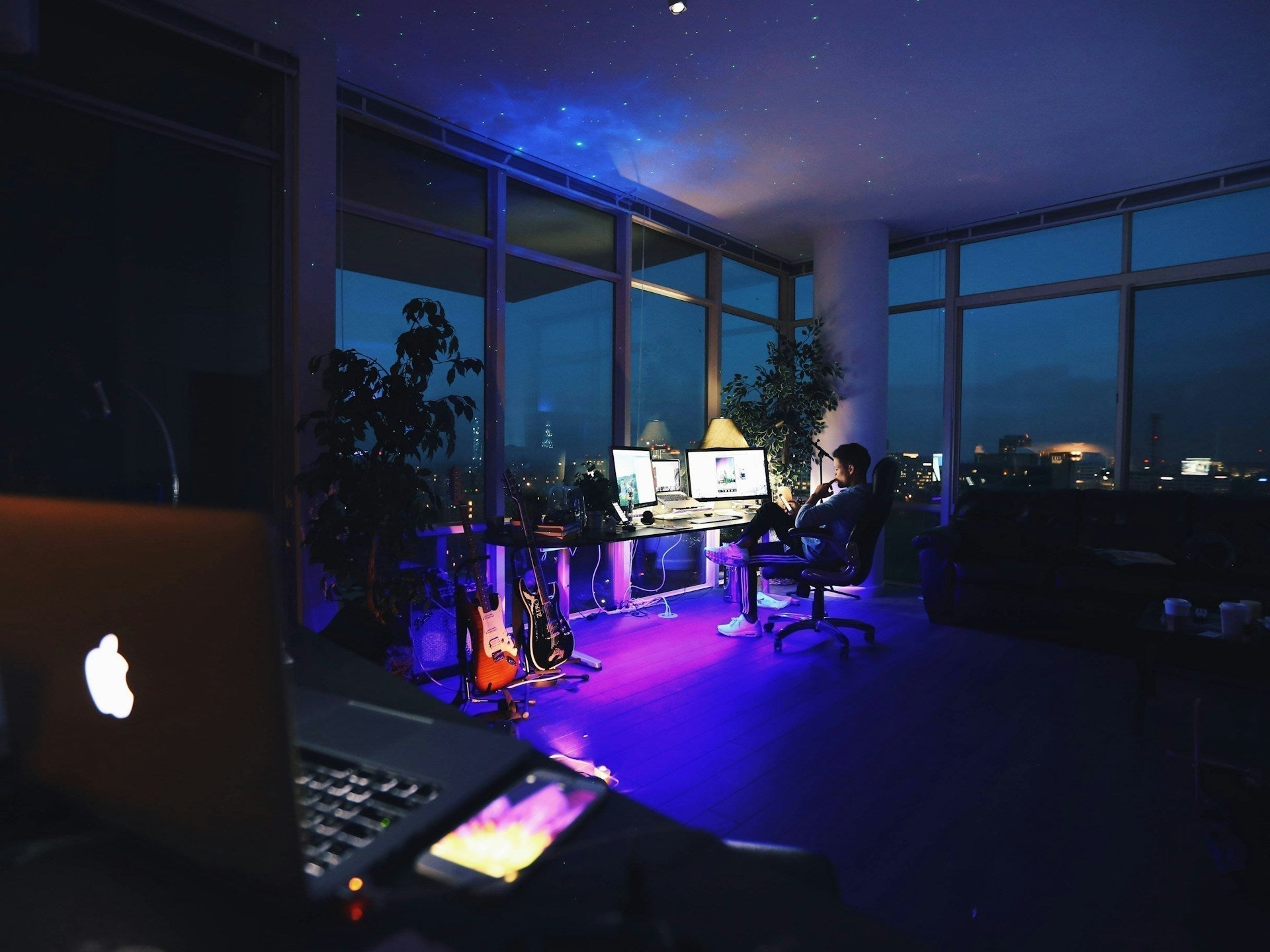 Home office lighting with multiple screens, desk lamp, and night city view. Image by Roberto Nickson via www.unsplash.com