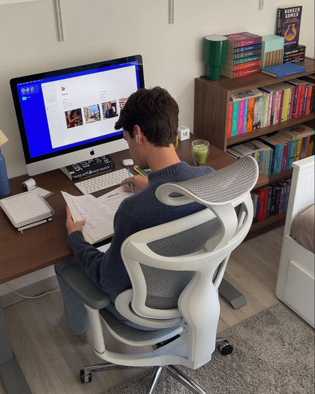 Man working while seated on an ergonomic chair, promoting focus and productivity at work.