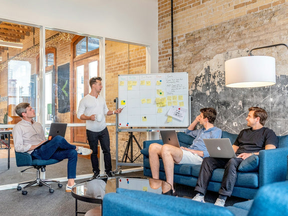 Team working with KPIs during a strategy meeting, discussing goals and performance metrics on a whiteboard.
