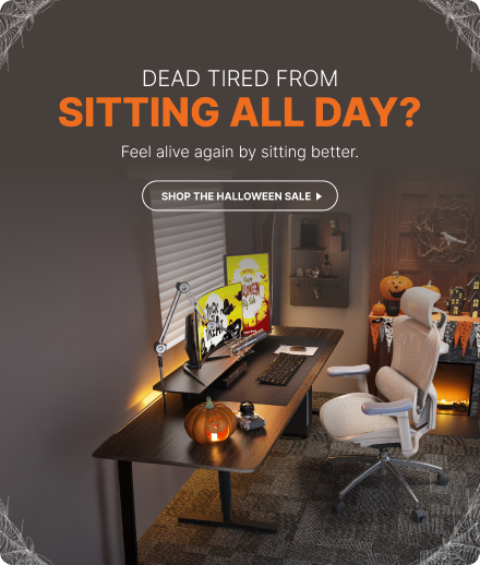 Ergonomic office chair in a Halloween-themed home office with pumpkins and warm desk lighting.