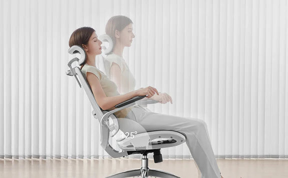 Woman sitting on a gray ergonomic chair reclined up to a 125-degree angle for enhanced comfort and relaxation.