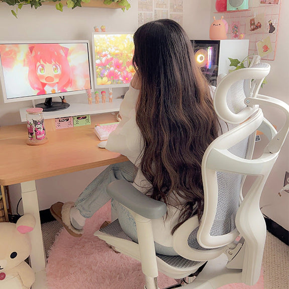 Woman sitting on white ergonomic chair in Australia in a cute home office setup with modern desk