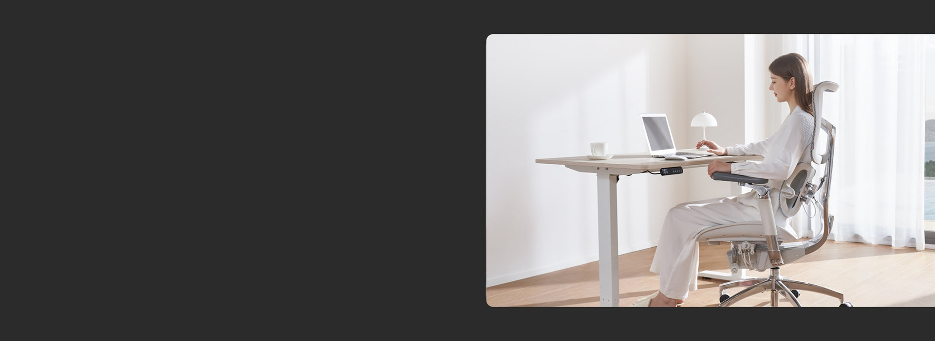 Woman using a laptop while seated on a white ergonomic chair in a work-from-home setup.