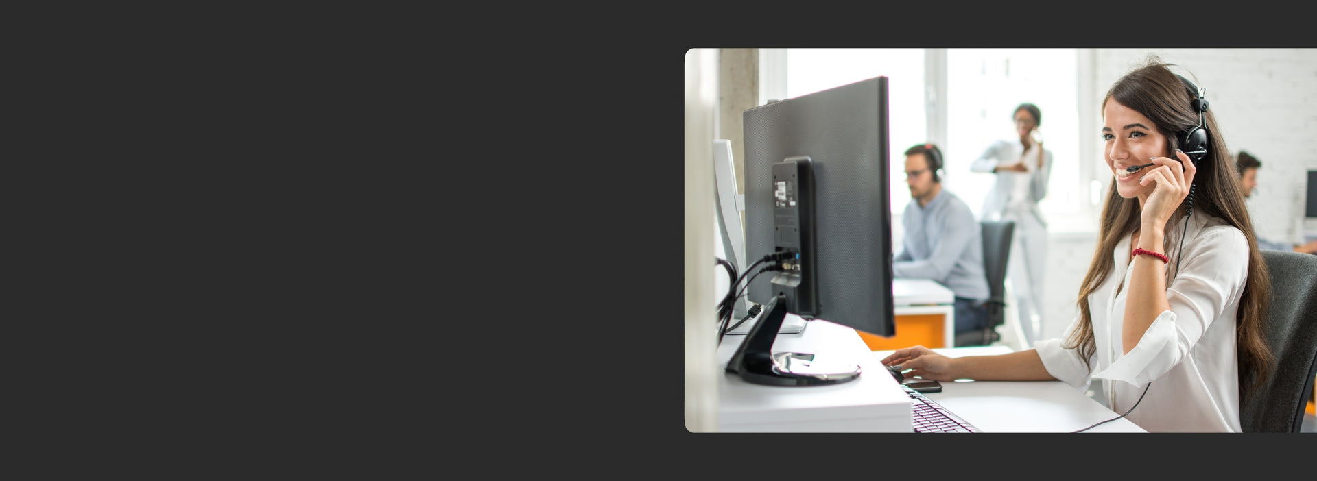 Banner image of a woman looking at a screen during an office meeting.