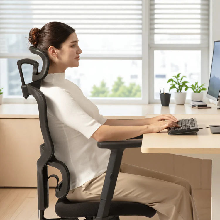 Side view of a woman working on a computer while seated on an ergonomic chair in Australia.